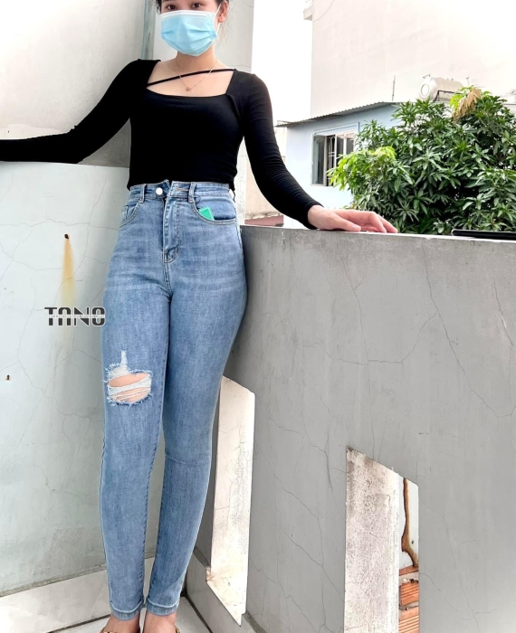 Quần jeans giãn ống ôm màu xanh nhạt rách 1 bên đùi,lai cuốn